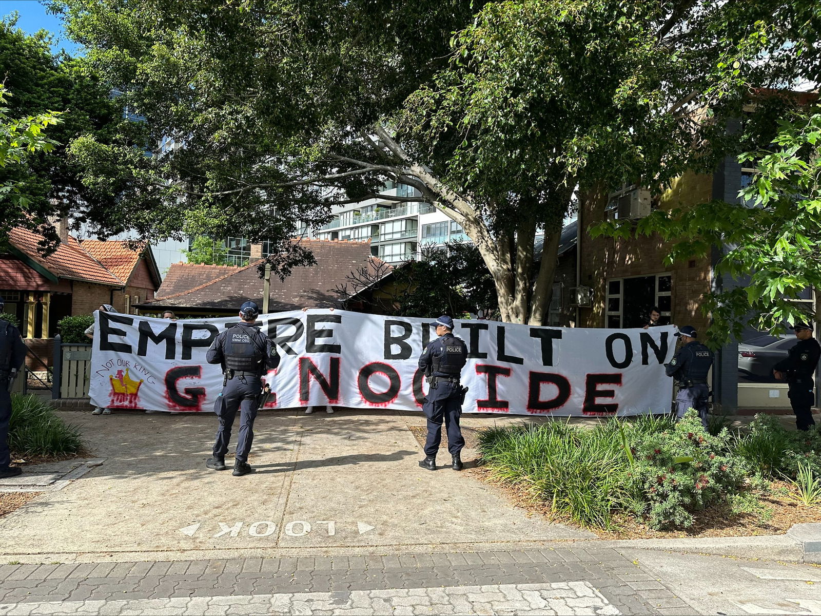 Bir kilisenin önünde soykırımdan bahseden bir pankart taşıyan protestocular