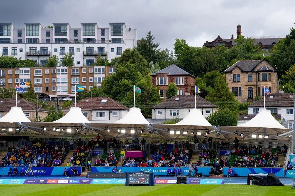 A picture across the grass at Scotstoun Stadium in Glasgow to the stands and the houses beyond.