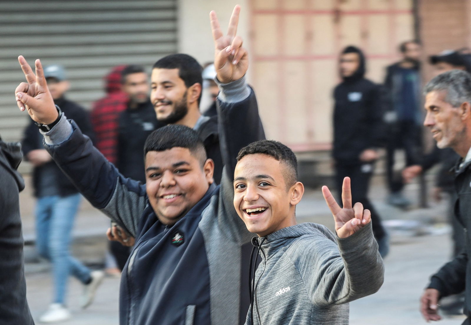 Young boys hold up a peace sign 