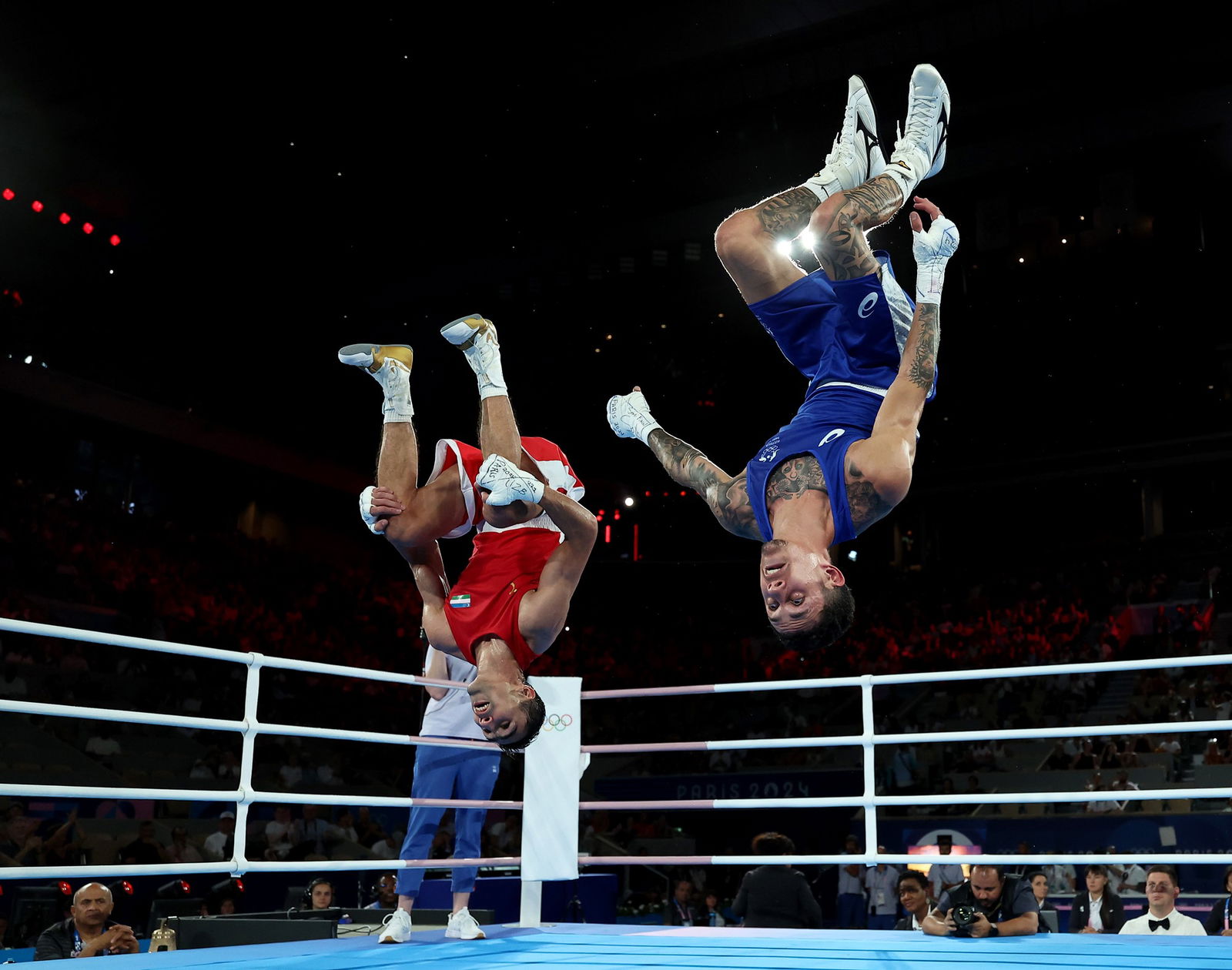 The two boxers are midair completing a backflip.