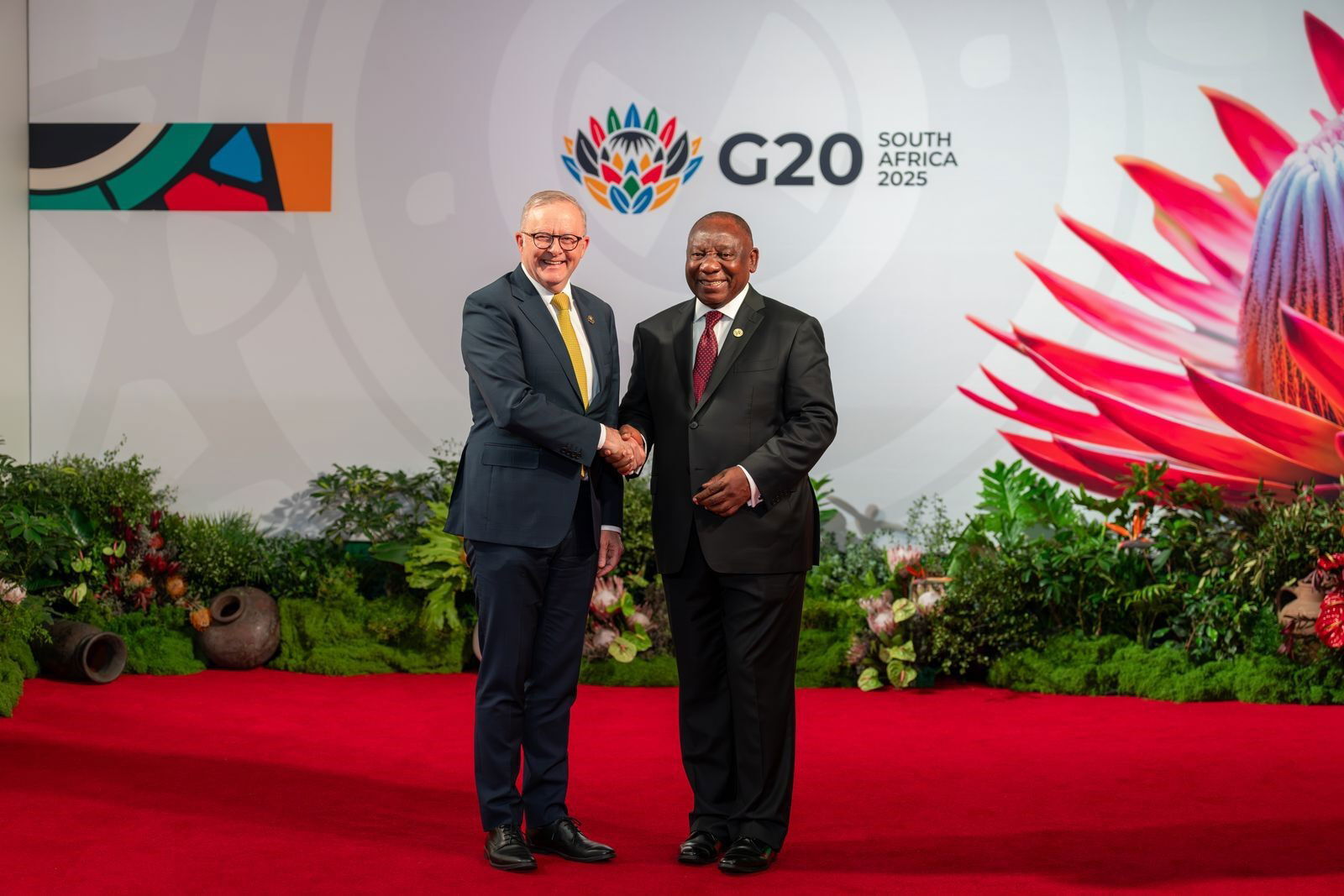 Dois homens apertam as mãos em um evento oficial.