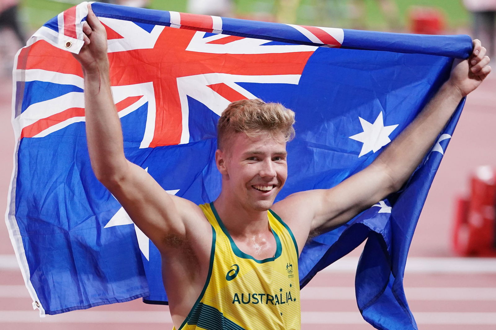 Ash Moloney holding an Australian flag above his head
