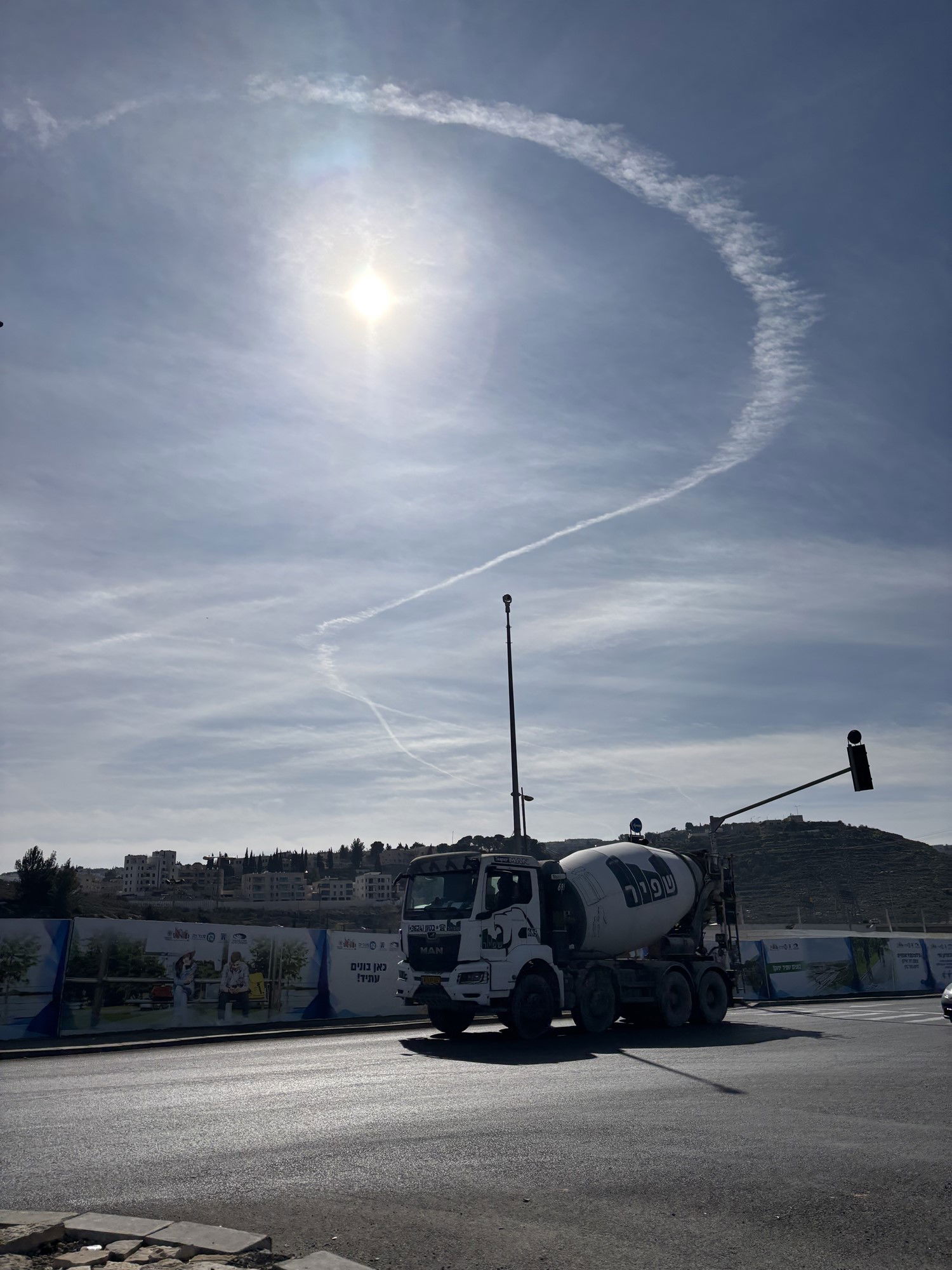 A con trail from a fighter jet creating a ribbon over the skies of Jerusalem.