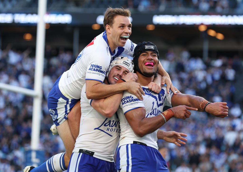 Stephen Crichton is jumped on by Bulldogs teammates after an NRL try.