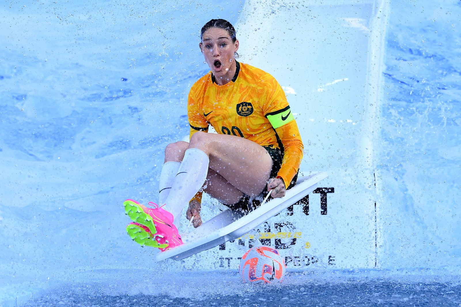 AFLW player Tayla Harris slides into ice water during the Fight MND Big Freeze at the G.