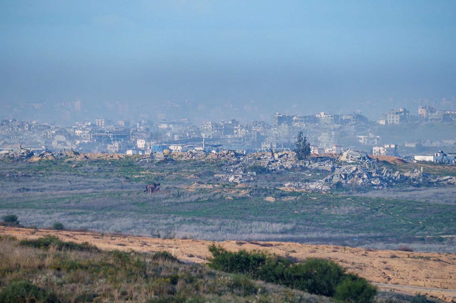 An entire neighbourhood turned to rubble, seen from a distance.