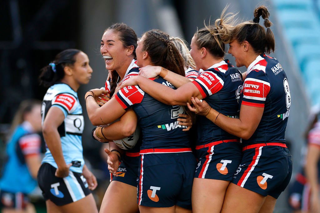 Roosters players hug Olivia Kernick after her NRLW grand final try against the Sharks.