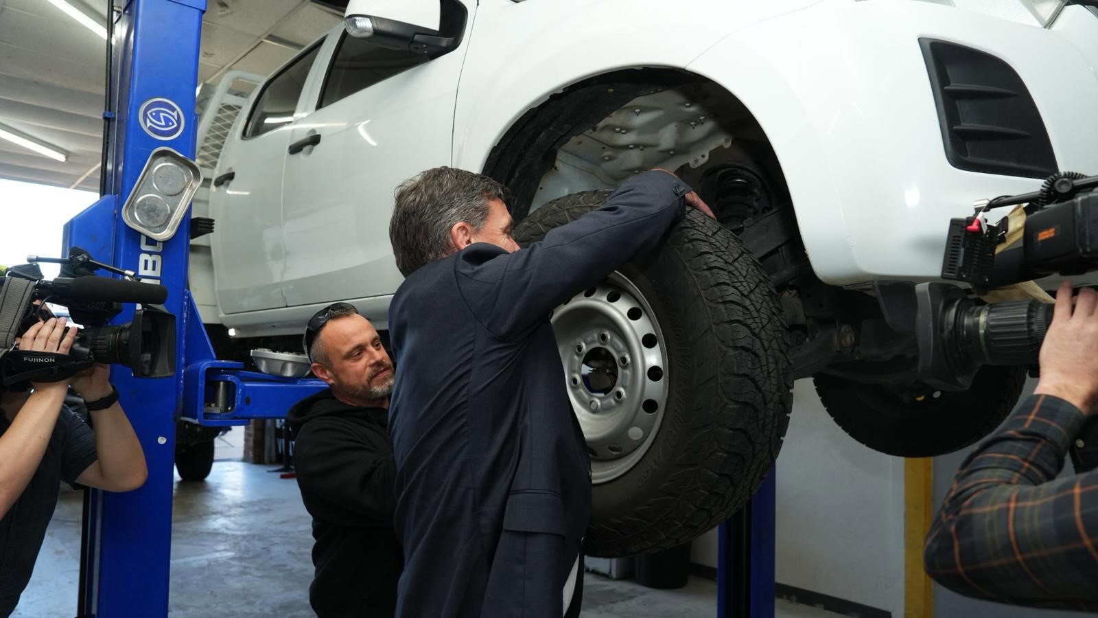 Angus Taylor takes a tyre off a car. 