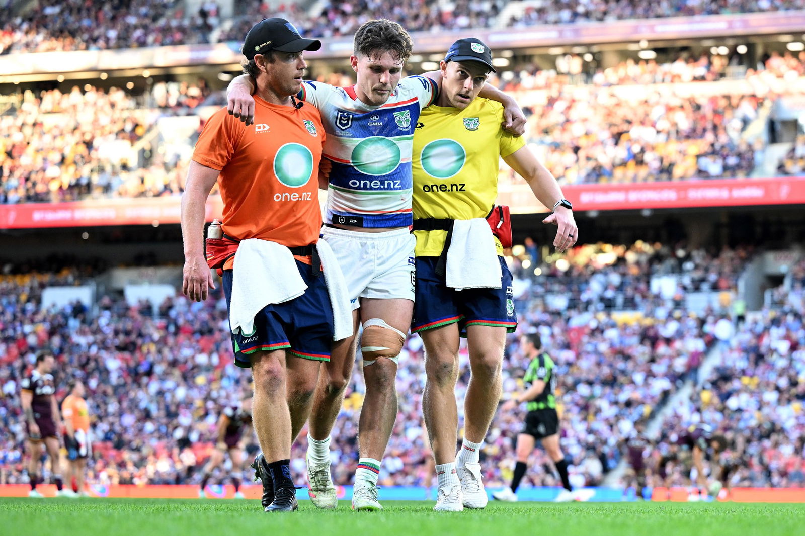 Luke Metcalf helped off the field at Lang Park.