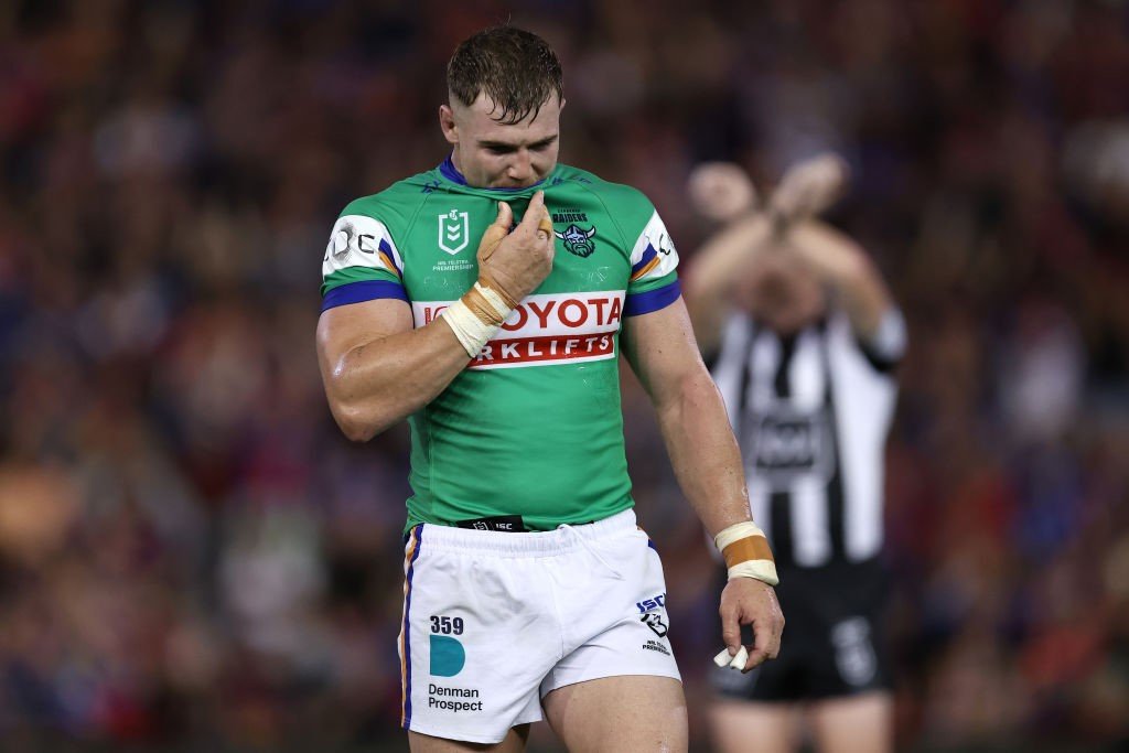 Canberra Raiders' Hudson Young walks off as the referee signals a cross with his arms behind him.