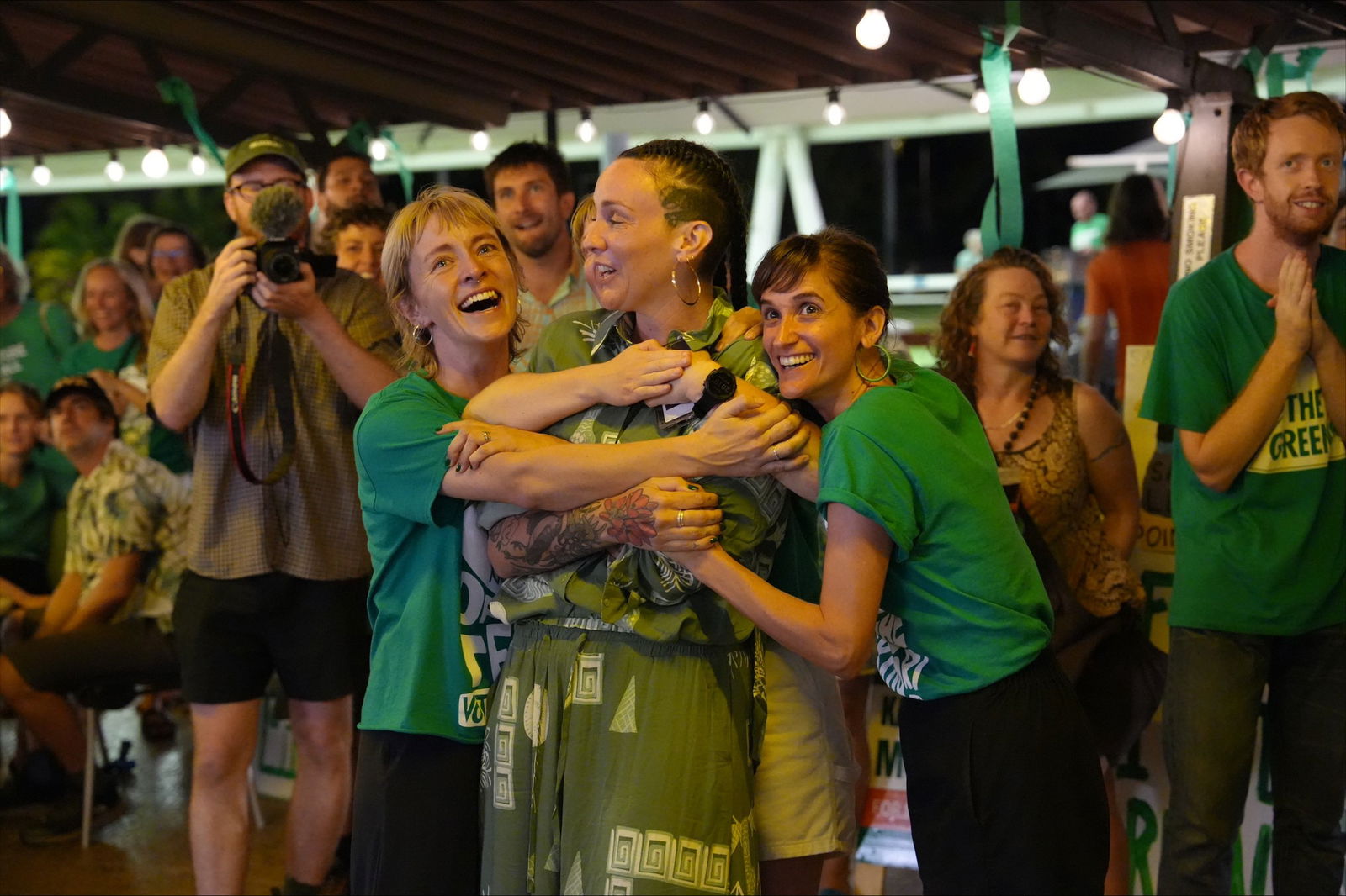 crowd of people wearing green smiling