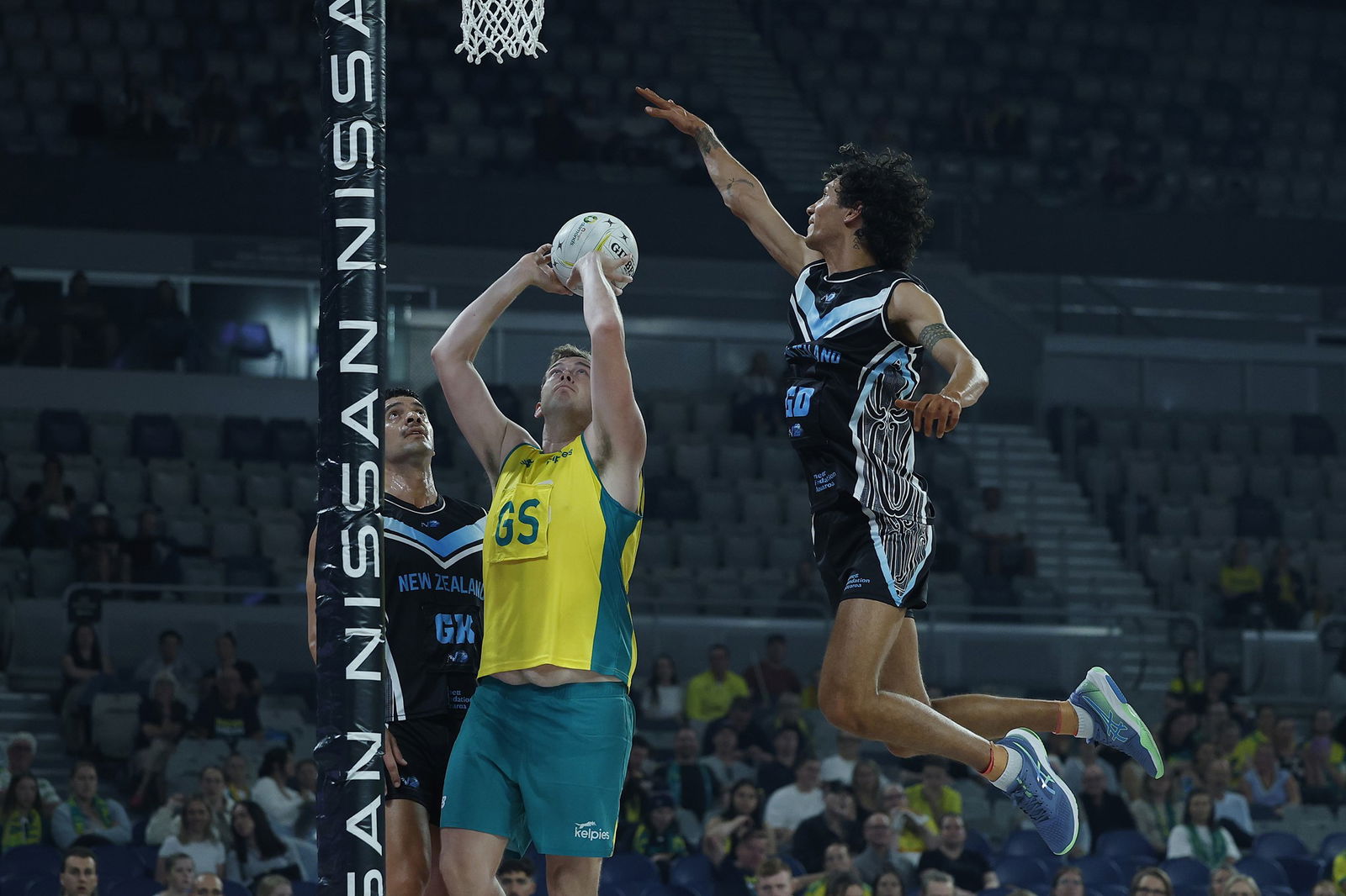 Jerome Gillbard of Australia shoots under pressure from Timothy Apisai of New Zealand