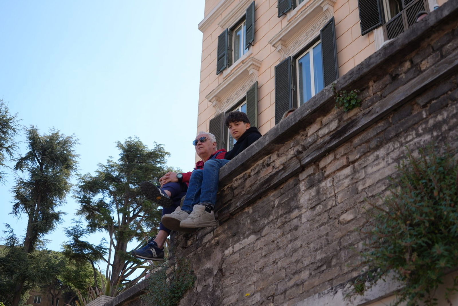 A man and child sits on a wall