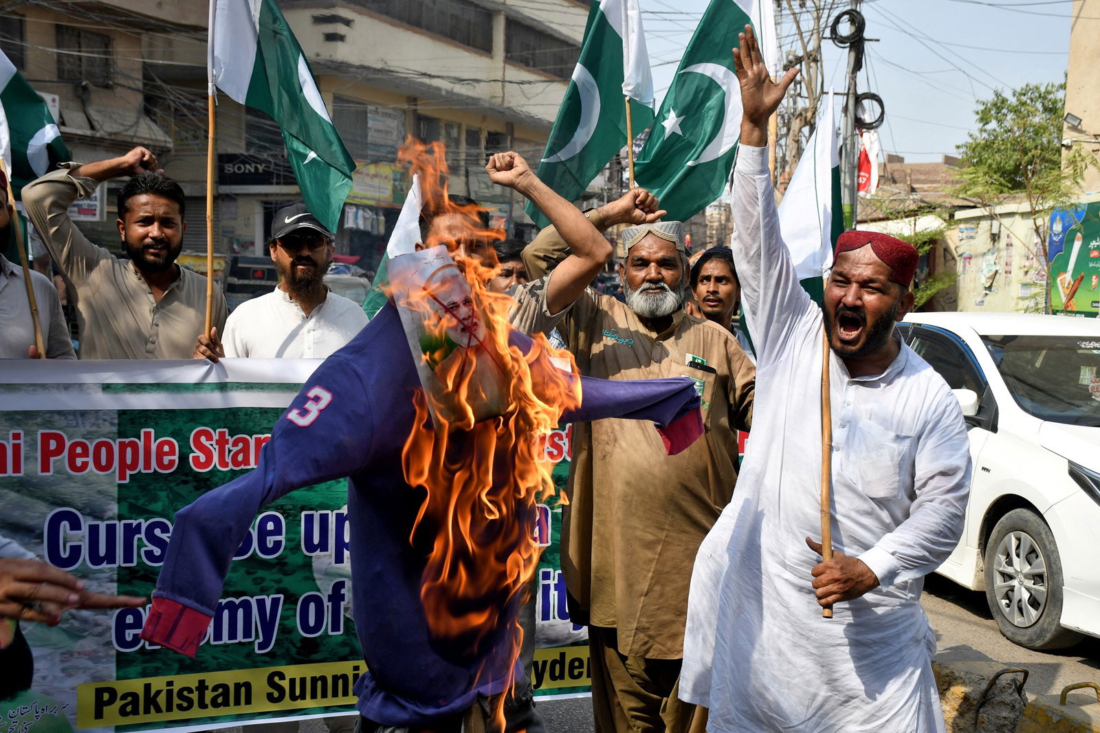 A picture of Narendra Modi's head burns on an effigy in the street during a protest