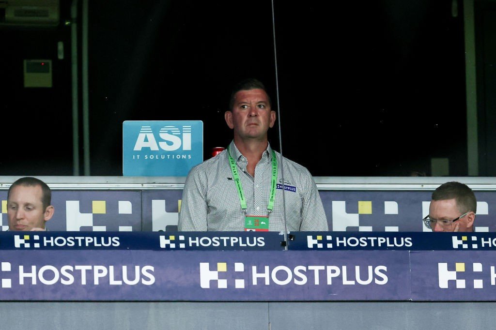 South Sydney Rabbitohs coach Jason Demetriou looks to the side while standing in th coach's box during an NRL game.