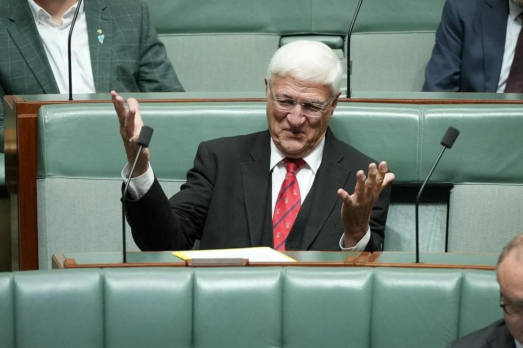Bob Katter sits in the House of Representatives and gestures with his arms.