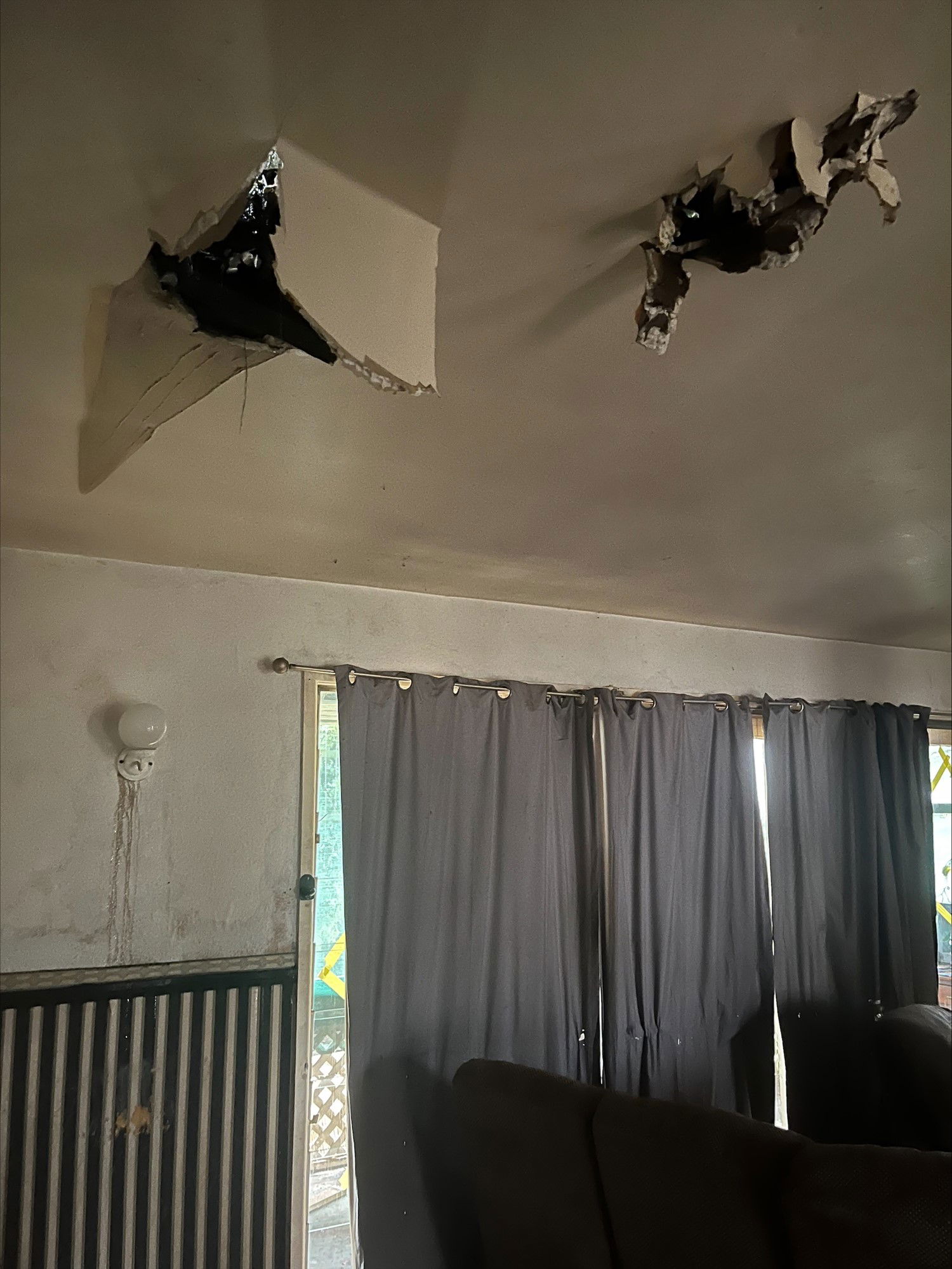 The tree smashed holes in the roof. punctured white plaster in a living room. 