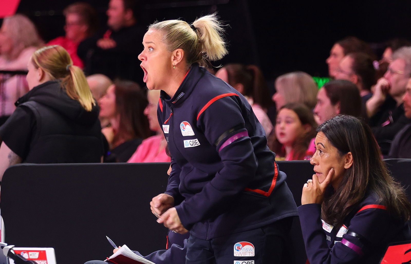 Briony Akle stands and yells as Noeline Taurua sits next to her with her hand holding up her chin