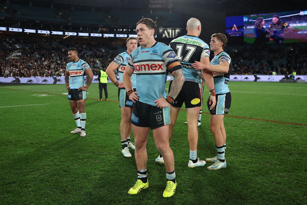 Cameron McInnes and other Cronulla Sharks players stand on the field after a loss.