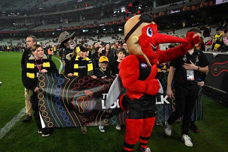People take part in The Long Walk to the ‘G event ahead of the AFL Round 11 match between the Essendon Bombers and the Richmond Tigers at Melbourne Cricket Ground in Melbourne, Friday, May 23, 2025.