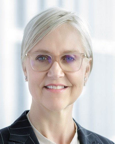 A headshot of Susan with blonde hair and glasses