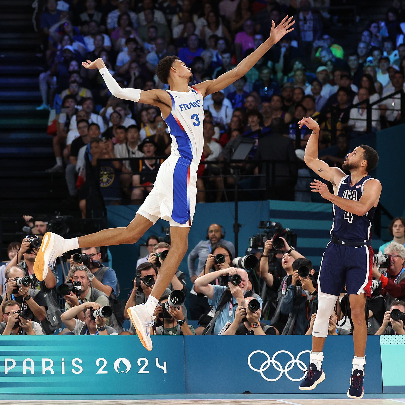 France's Victor Wembanyama tries to block shot by USA's Stephen Curry in the men's basketball gold medal game.