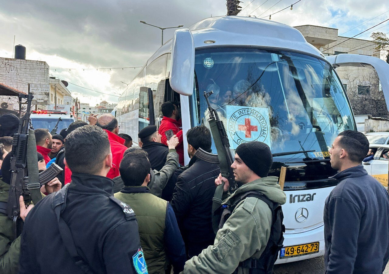 Several people crowd around a bus.