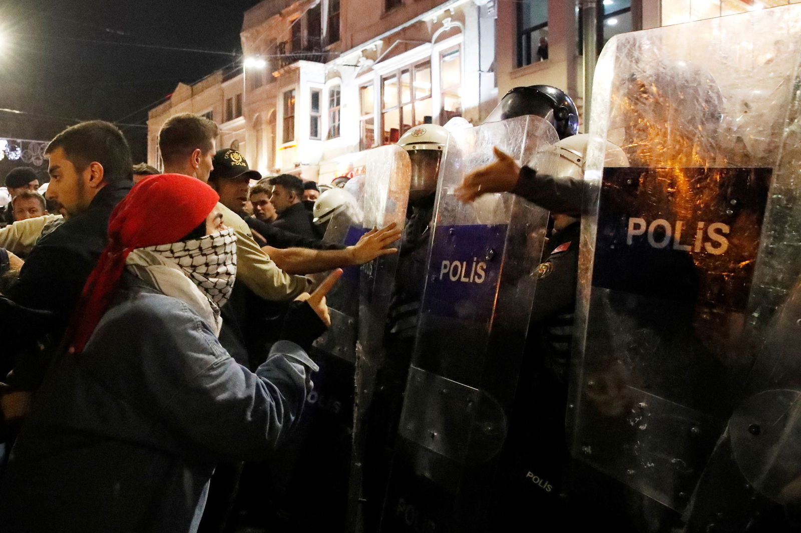 Prosterers standing in front of police in riot gear. 