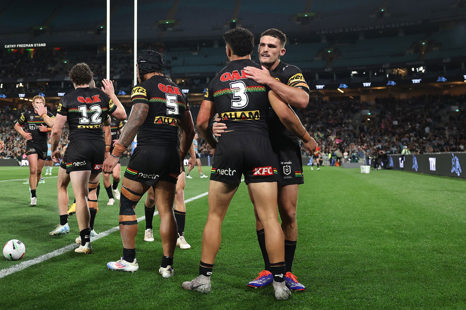 Nathan Cleary hugs Penrith Panthers teammates during an NRL game.