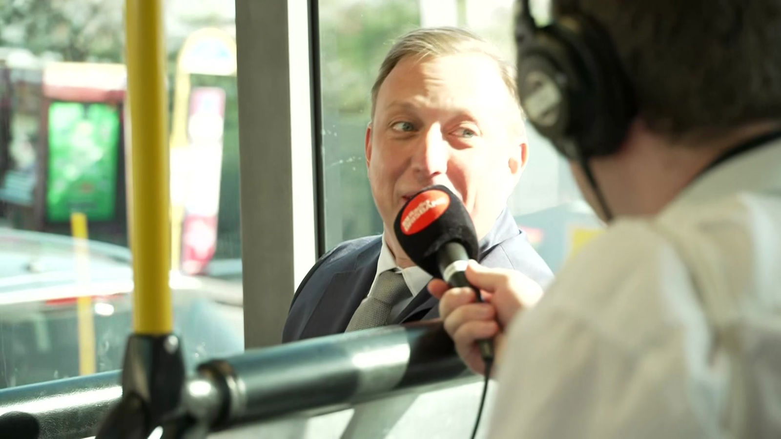 A man being interviewed on the bus.