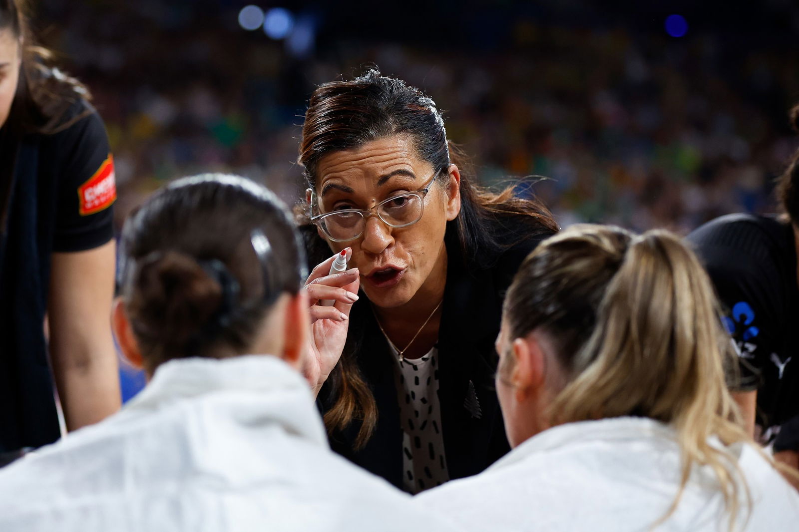 A coach points her pen and gives direction to players