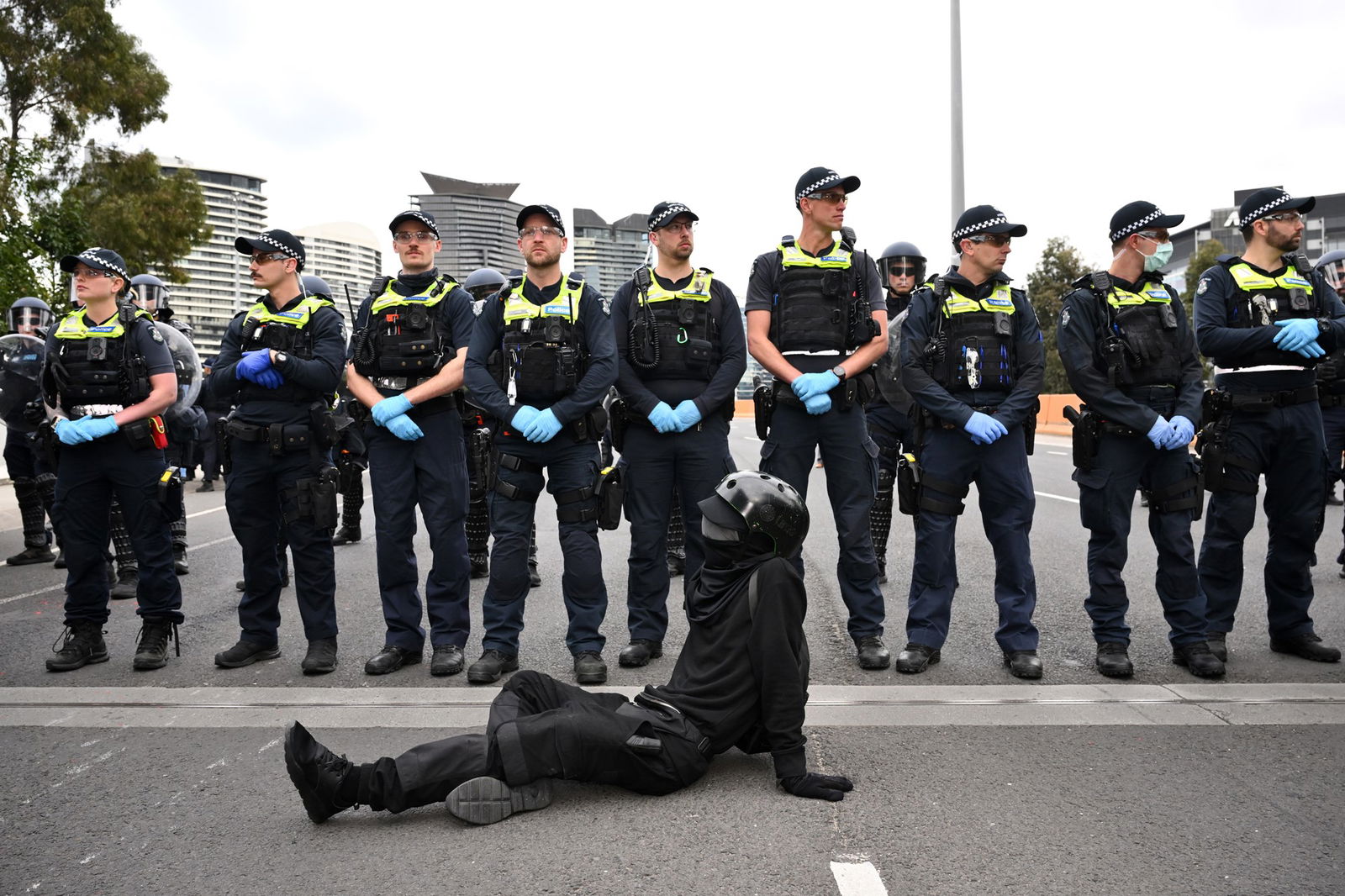 A line of police and a single protester