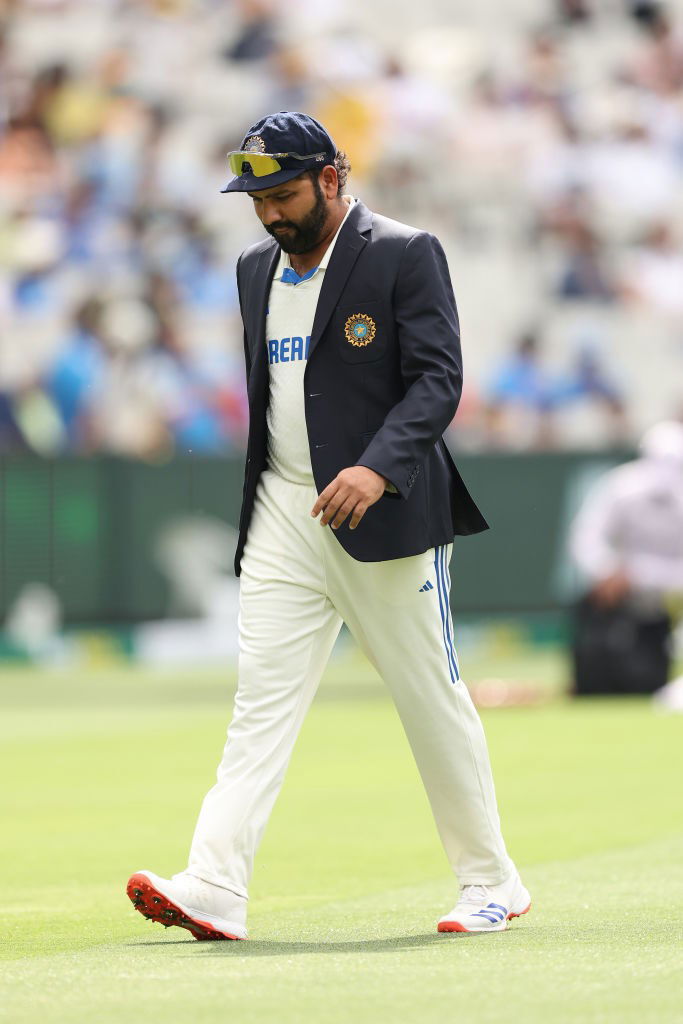 India cricket captain Rohit Sharma walks on the field in a blazer.