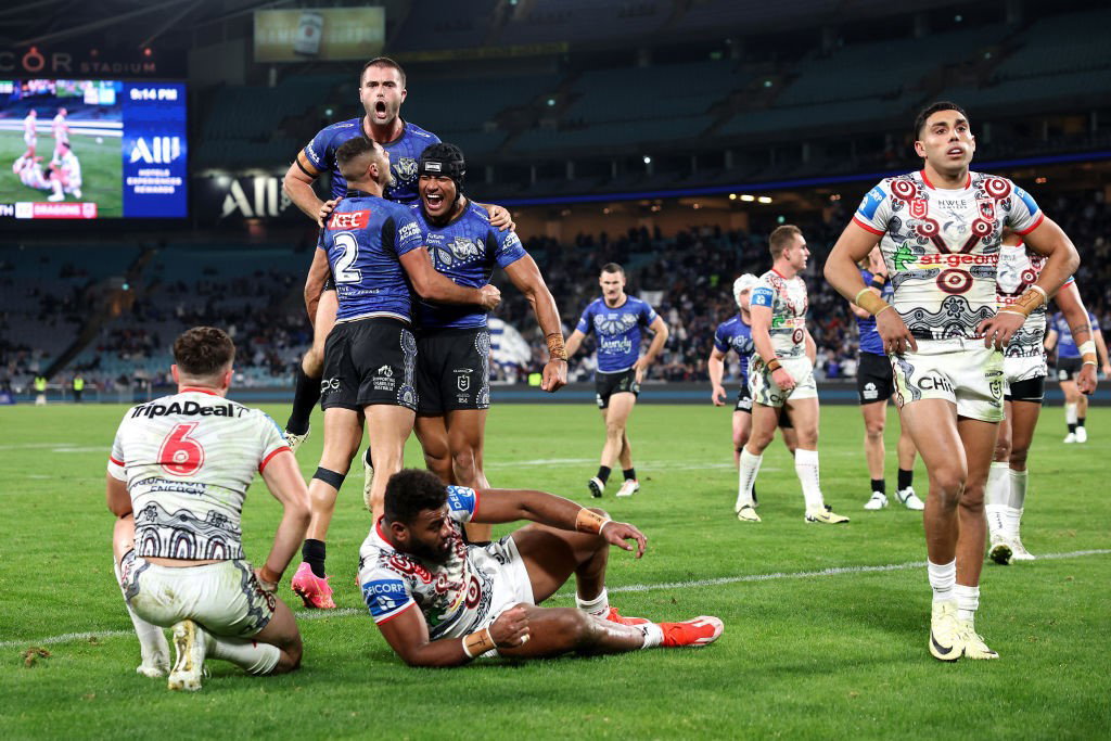 BUlldogs players celebrate a try as Dragons players lament during an NRL game.