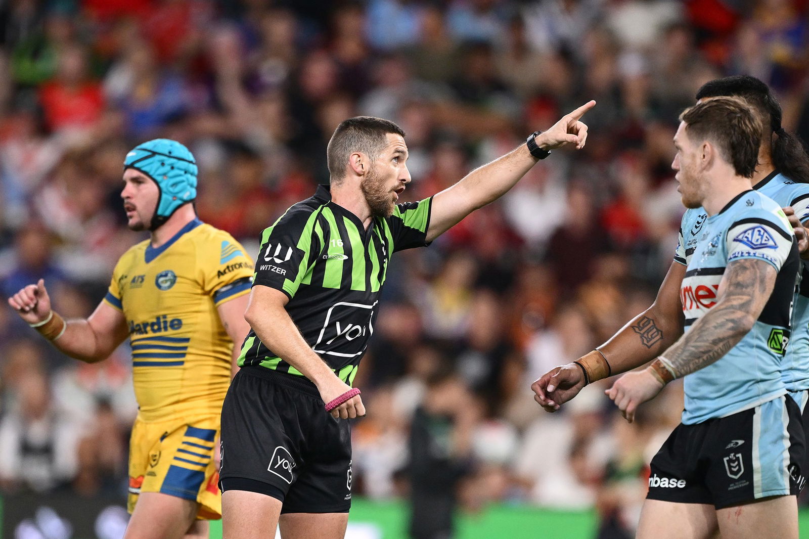 NRL referee Peter Gough points during a Sharks-Eels NRL game.