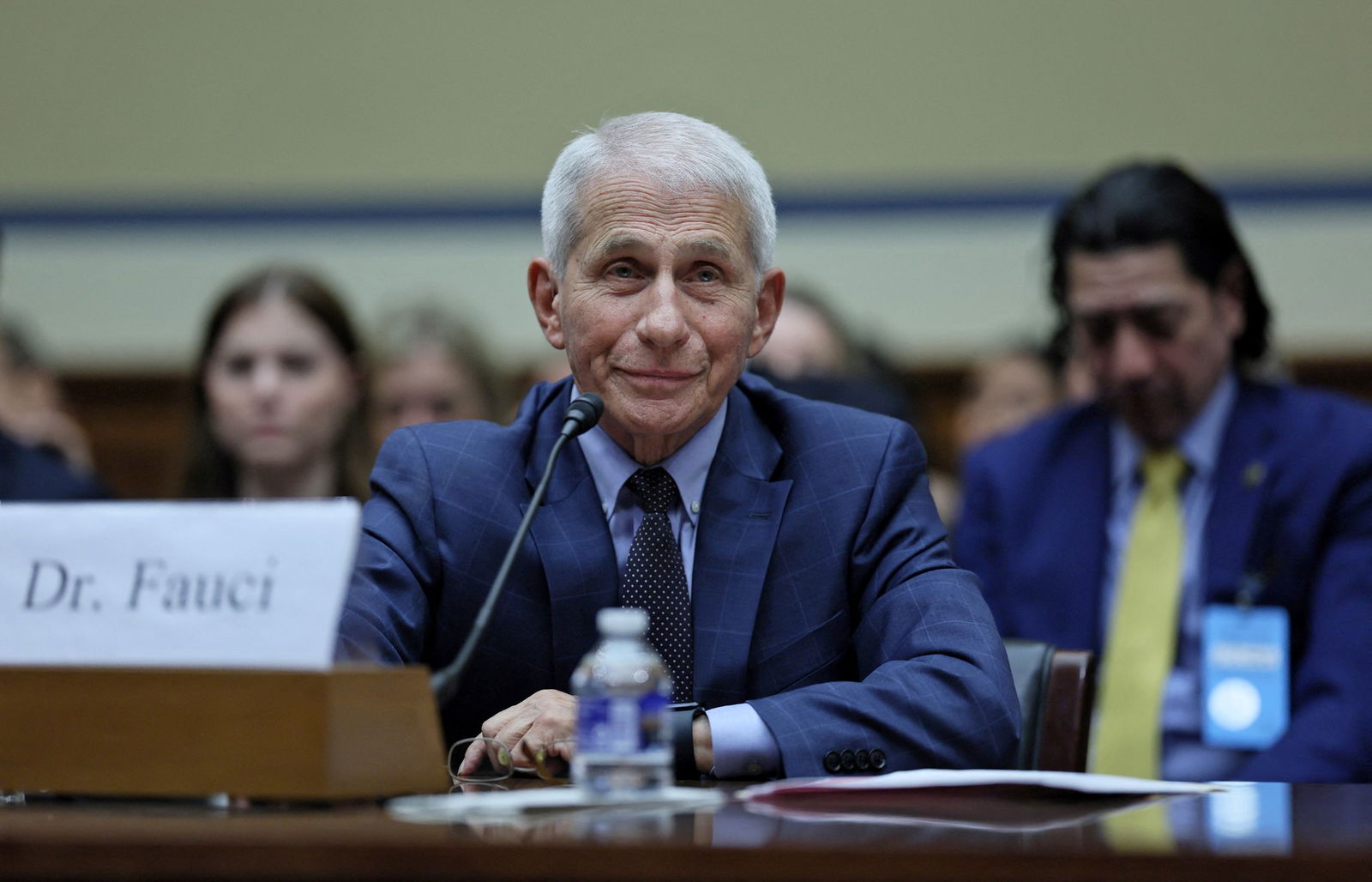 Anthony Fauci aan een bureau met microfoons.