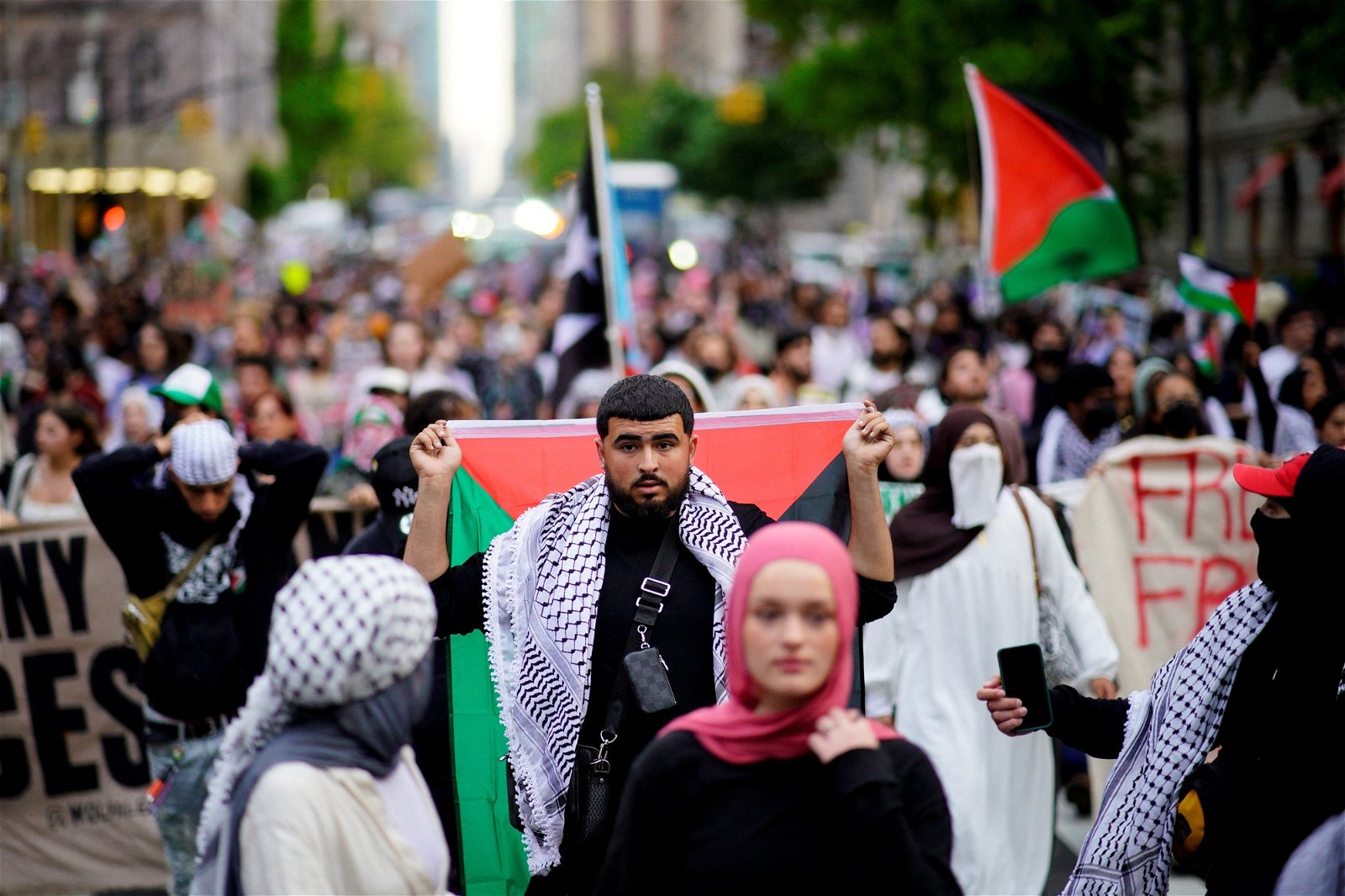 A crowd carrying palestine's flag. 
