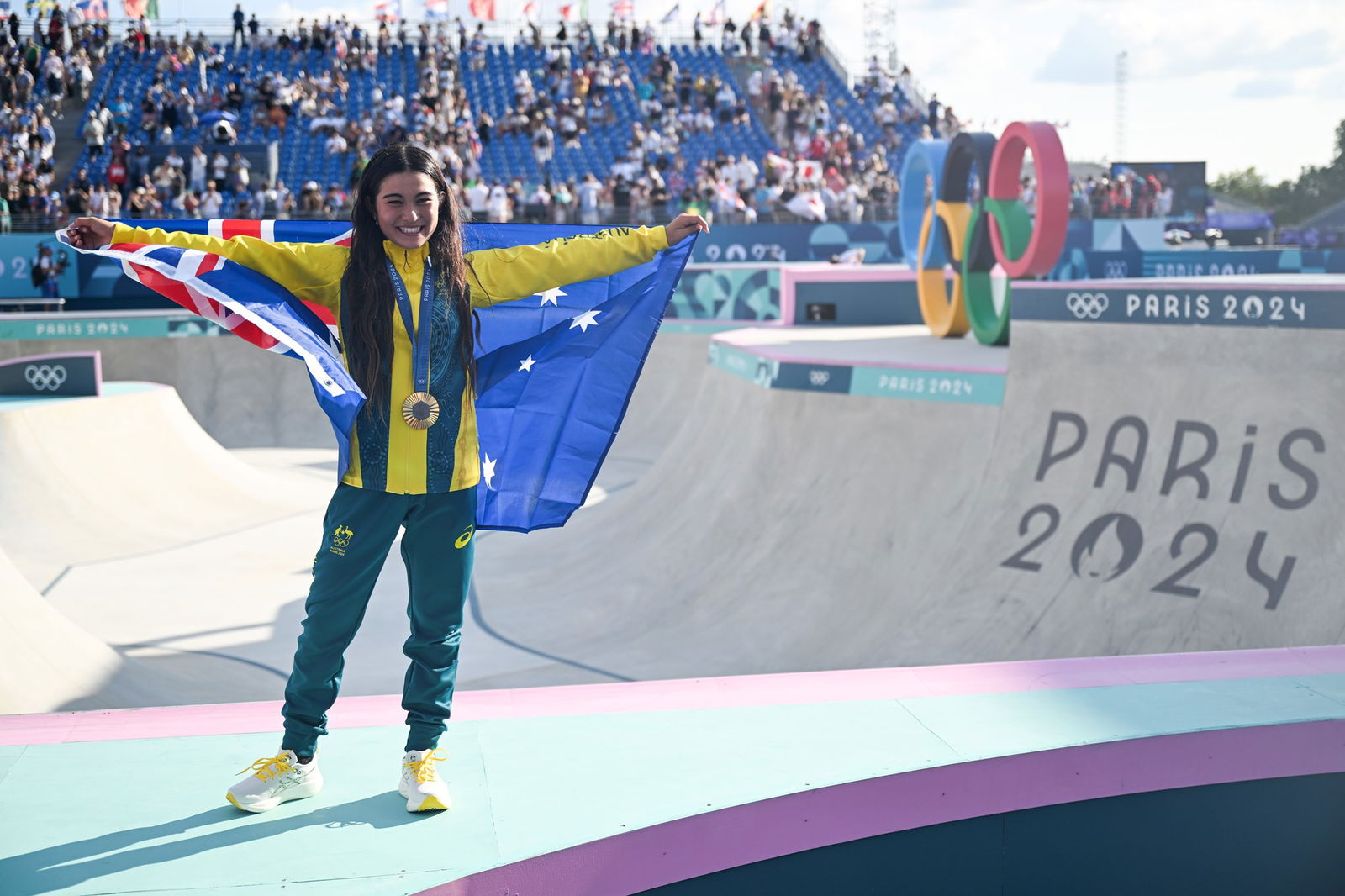 Arisa Trew with the Australian flag and a gold medal after her win in the women's skateboard park final