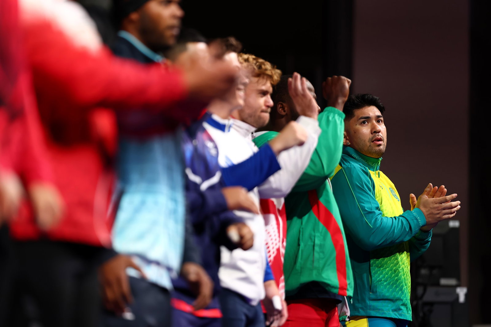 Weightlifters clapping on-stage before the event begins.