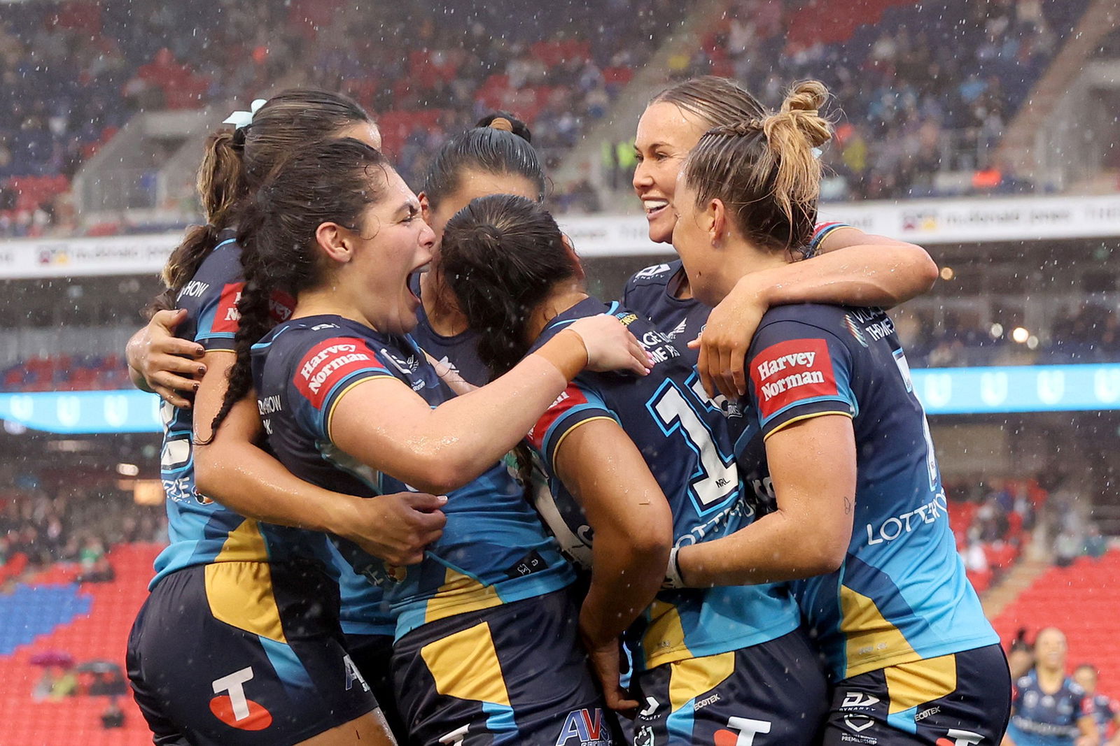 Gold Coast Titans NRLW oyuncuları yağmurda kutluyor.