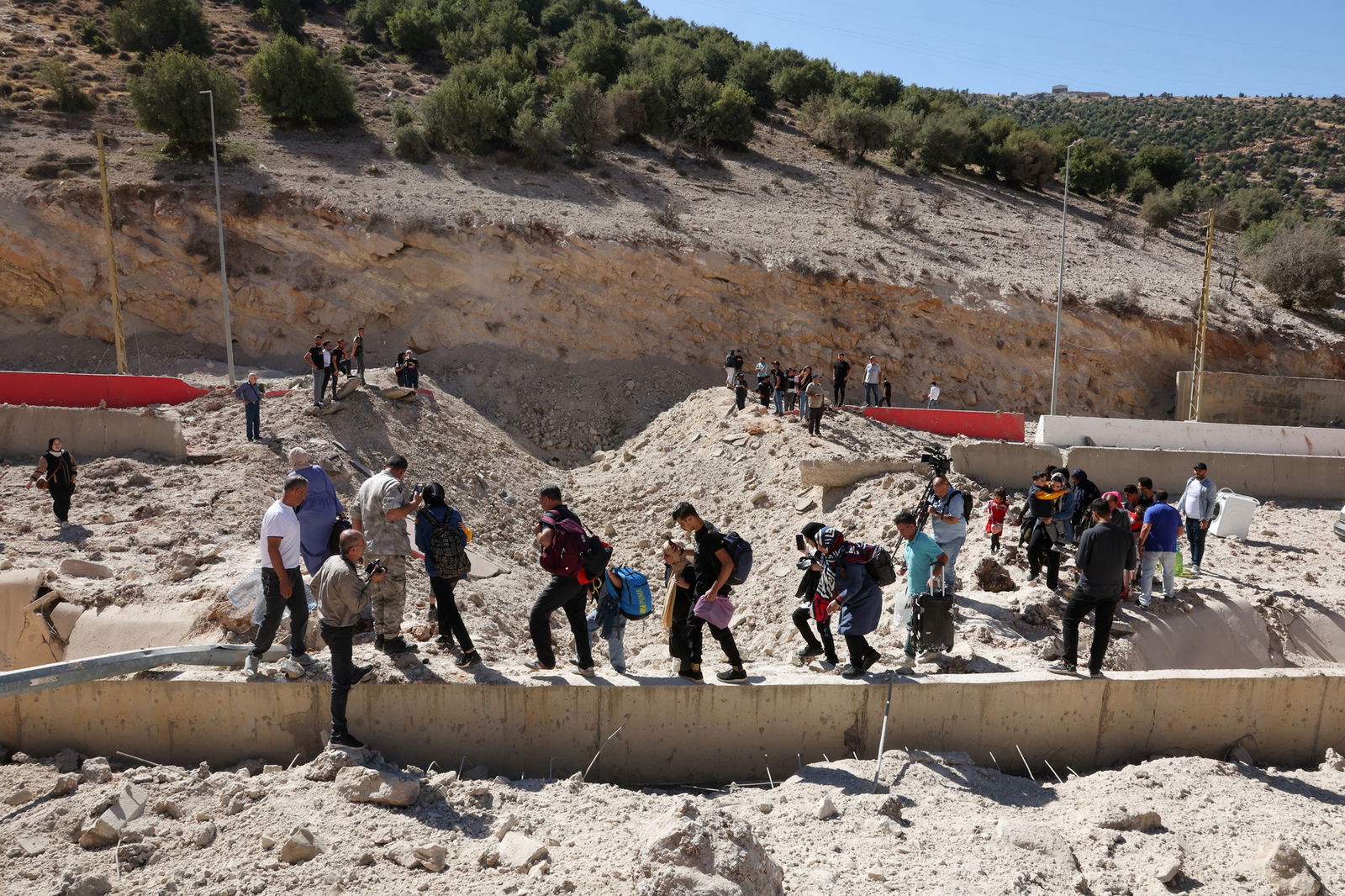 A small crowd of people standing on small structures surrounded by rubble.