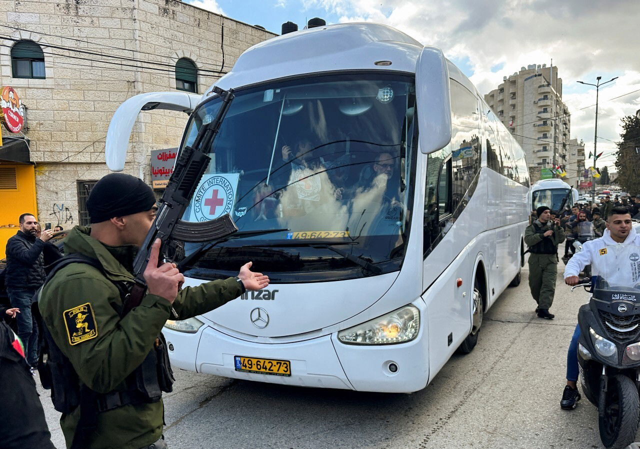 Several people crowd around a bus.