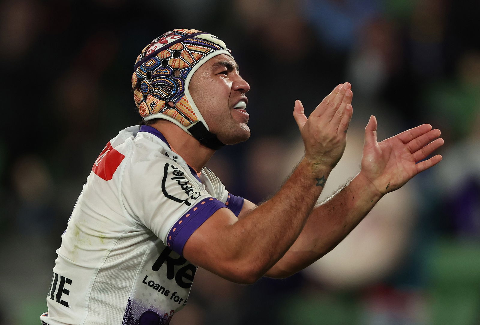 Melbourne Storm NRL player Jahrome Hughes claps his hands during a game.