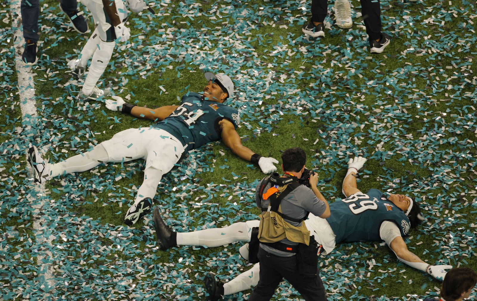 Players make snow angels in the confetti