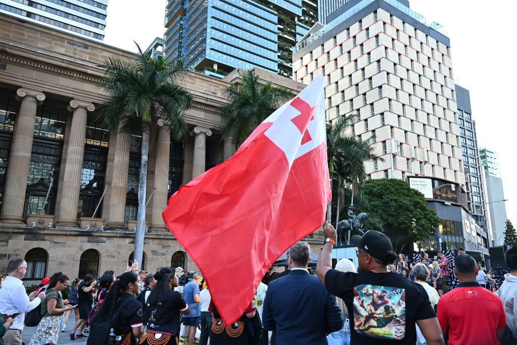 A Tongan flag waves in front of Brisbane City Hall.