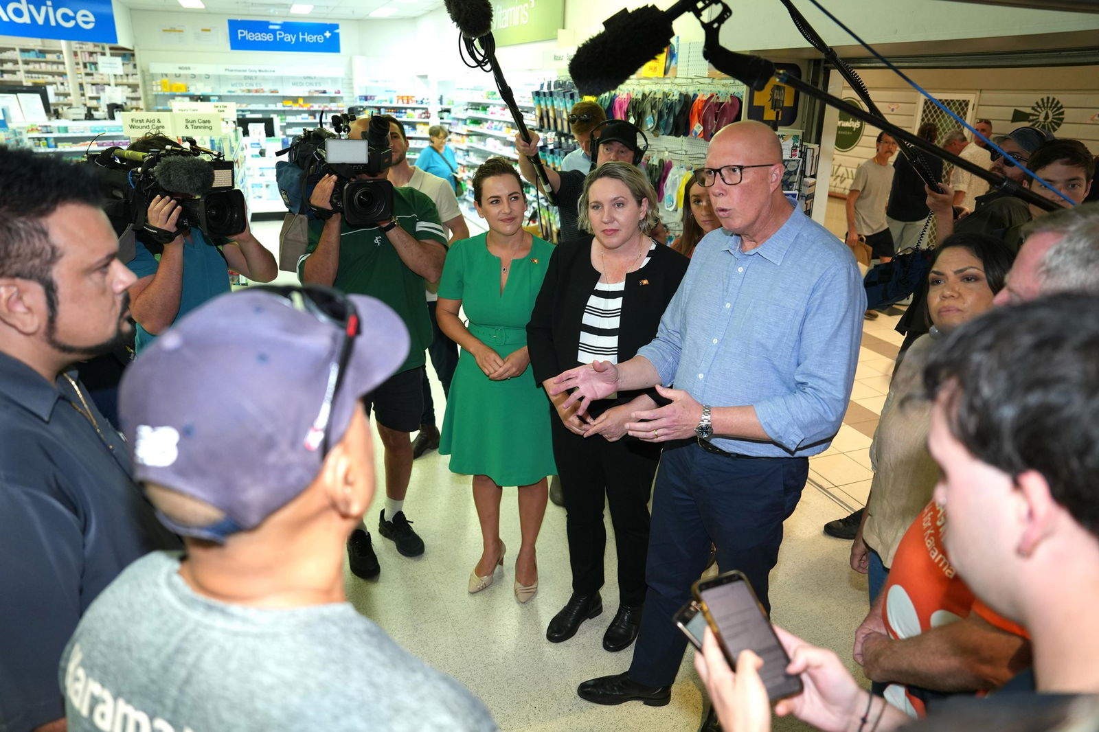 Peter Dutton speaks to business owners in front of a large press pack.