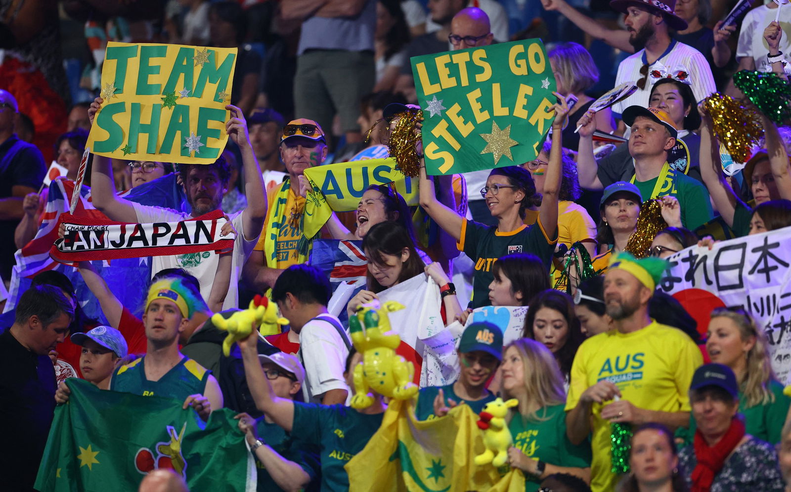 Australian fans hold signs saying Team Shae and Lets Go Steelers in the crowd.