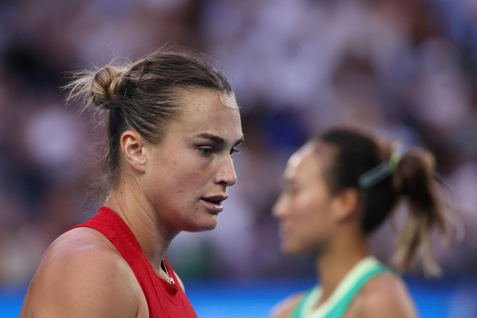 Aryna Sabalenka and Qinwen Zheng on court.