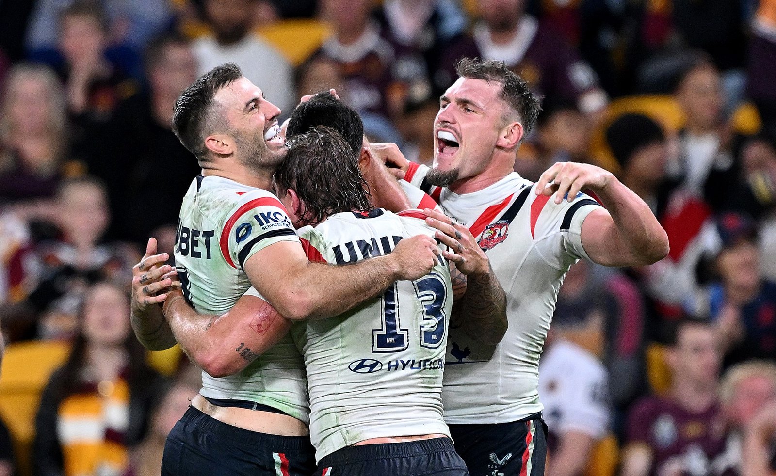 Roosters players hug after a try in an NRL game.