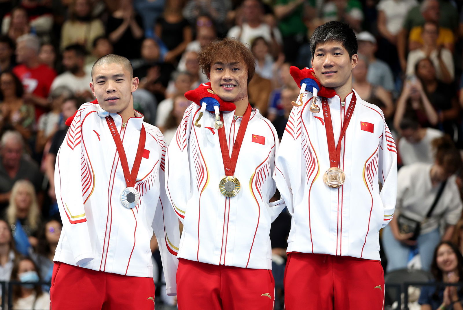 Gold medallist Yuan Weiyi (C), silver medallist Guo Jincheng (L) and bronze medallist Wang Lichao, of China, after the men's 50m S5 backstroke final.